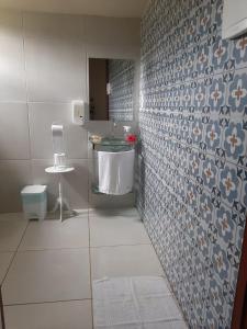 a bathroom with a sink and a tiled wall at Casa da Marluce in Fernando de Noronha