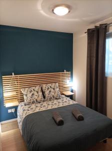 una camera con un grande letto con una parete blu di Ty Moutik a Plougonvelin