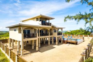 une maison avec un balcon et une piscine dans l'établissement Marsh Madness, à Maya Beach