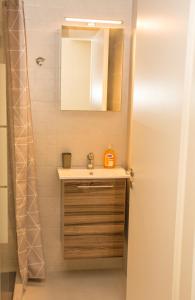 een badkamer met een wastafel en een spiegel bij Central Luxury Studio 2 in Korinthos