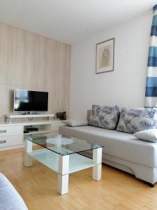 uma sala de estar com um sofá e uma mesa de café em vidro em Apartment Bencic em Umag