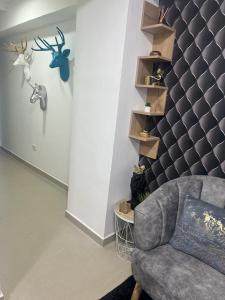 - un salon avec une chaise et un mur avec des étagères dans l'établissement Acogedor apartamento en Itagui, à Itagüí