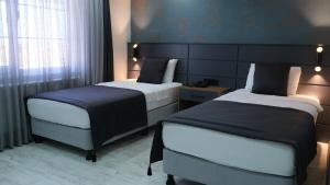 een hotelkamer met 2 bedden en een raam bij Lagom Hotel in Edirne