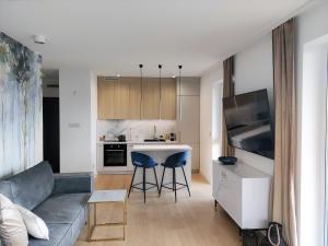 a living room with a couch and a kitchen at Marina View 15 & SPA in Dziwnów