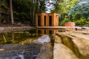 a wooden structure sitting on top of a body of water at Apartmány NONE in Branná