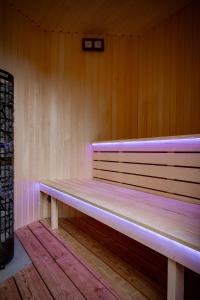 ławka w pokoju z fioletowymi światłami w obiekcie Apartmány NONE w mieście Branná