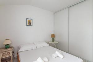 a bedroom with a white bed with towels on it at Maison Avocette - Welkeys in Saint-Trojan-les-Bains