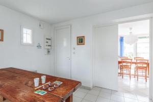 a kitchen with a wooden table and a dining room at Maison Avocette - Welkeys in Saint-Trojan-les-Bains