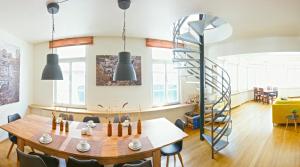 a dining room with a wooden table and a spiral staircase at LOFT13 Traumhafte Wohnung mit Terrasse für 8 Gäste in Monschau