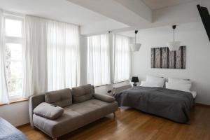 een woonkamer met een bank en een bed bij LOFT13 Traumhafte Wohnung mit Terrasse für 8 Gäste in Monschau
