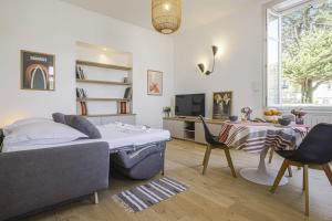 uma sala de estar com uma cama e uma mesa em Splendid studio right in the center of Biarritz - Welkeys em Biarritz