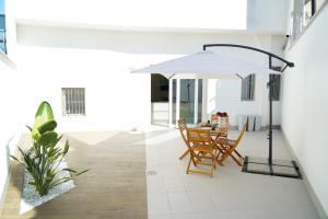 a dining room with a table and an umbrella at Miro Luxury Home in San Vito dei Normanni
