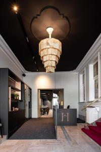 a lobby with a large chandelier hanging from the ceiling at B&B Herenhuis in Izegem