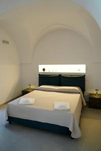 a bedroom with a large bed with two towels on it at Miro Luxury Home in San Vito dei Normanni