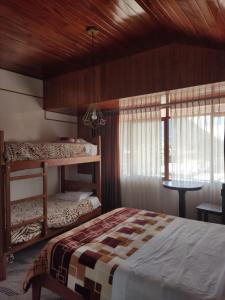 Un dormitorio con dos literas y una ventana. en Suzet House, en Oxapampa