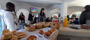 un grupo de personas de pie alrededor de una mesa con pasteles en HOTEL CAASAMA en Santa María