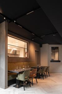 B&B Herenhuis في إيزيغيم: غرفة طعام مع طاولات وكراسي ومرآة