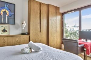 ein Schlafzimmer mit einem Bett, einem Stuhl und einem Fenster in der Unterkunft Superb 1 bedroom flat with balcony near the Eiffel Tower - Paris - Welkeys in Paris