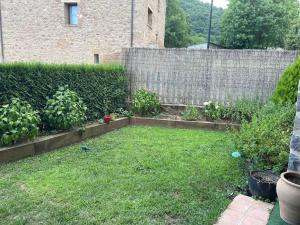 a backyard with a fence and a yard with grass at Riudaura in Riudaura