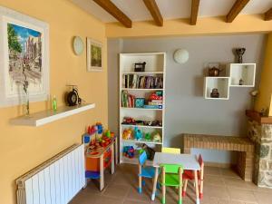 a room with a table and chairs and a book shelf at Riudaura in Riudaura