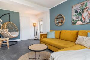 a living room with a yellow couch and a table at KAKADU - Zentral - Workplace - Gemeinschaftsterrasse, SNES in Frankenberg
