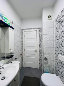 ein Badezimmer mit einem weißen WC und einem Waschbecken in der Unterkunft Lake Escape - Home 2 in Tirana