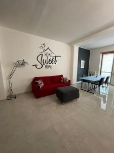ein Wohnzimmer mit einem roten Sofa und einem Tisch in der Unterkunft Terrace house appartamento mq 80 adiacente ospedale e clinica in Piacenza