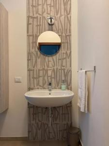 een badkamer met een wastafel en een spiegel bij Terrace house appartamento mq 80 adiacente ospedale e clinica in Piacenza