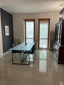 ein Esszimmer mit einem blauen Tisch und Stühlen in der Unterkunft Terrace house appartamento mq 80 adiacente ospedale e clinica in Piacenza