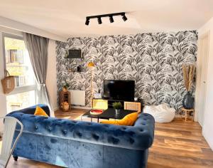 sala de estar con sofá azul y papel pintado en Appartement 2 chambres avec parking, en Pontarlier