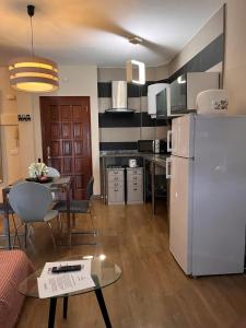 eine Küche mit einem weißen Kühlschrank und einem Tisch mit Stühlen in der Unterkunft Dream Central Toscal in Santa Cruz de Tenerife