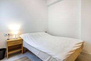 a bedroom with a bed and a nightstand with a white bedspread at SEA VIEW, walking distance! Refurbished 2 bed, modern. 20 min. from Alicante Airport in Santa Pola