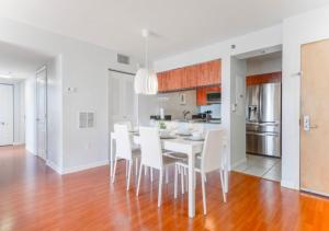 a kitchen and dining room with a white table and chairs at Exquisite Ocean View 3 BR Apartment in Miami