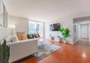 a living room with a white couch and a tv at Exquisite Ocean View 3 BR Apartment in Miami
