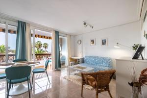 een woonkamer met een blauwe bank en een tafel bij Palm Mar Flat by LoveTenerife in Palm-mar