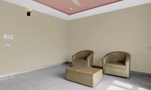duas cadeiras e uma caixa numa sala de espera em Itsy By Treebo - Kattari Komforts em Chikmagalūr