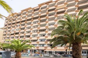 a large building with palm trees in front of it at Flamingo Apartment on the south near the beach in Palm-mar