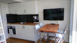 a small kitchen with a table and a tv on the wall at Strandstugan, Solviken in Rockneby