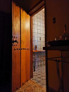 Ekpedz的住宿－Hotel Tihosuco Colonial，走廊上设有一扇门,通往一间铺有瓷砖地板的厨房