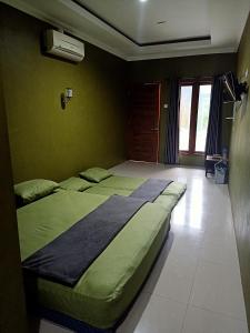 een slaapkamer met 2 bedden in een kamer bij Pendopo Kayuwanan Homestay Syariah in Yogyakarta