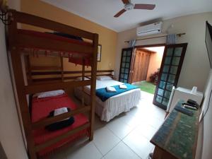 a bedroom with bunk beds and a door to a yard at Pousada Villa Verano in Paraty
