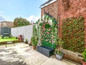 a brick wall with a flower garden on it at Homely 4 Bedroom large house inc FREE Parking - Great Location - Fast WiFi - Smart TV - sleeps up to 7! Close to Bournemouth & Poole Town Centre & Sandbanks in Bournemouth