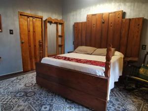 a bedroom with a large bed with wooden headboards at Hotel Tihosuco Colonial in Ekpedz