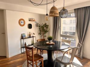 Appartement 2 chambres avec parking في بونتارليه: غرفة طعام مع طاولة وكراسي