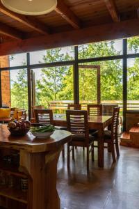 a dining room with a table and chairs and windows at The GreeNest Lodge in Pucón