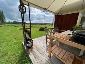 a deck with a grill and a table and an umbrella at Aldermyran - 1800-talstorp i Möklinta in Möklinta