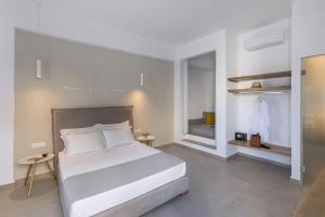 a bedroom with a large white bed and some shelves at Vivianna's View in Azolimnos Syros