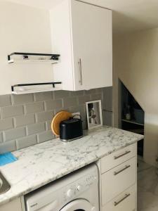 a kitchen with a white counter top with a dishwasher at Charming Town centre 3 double beds home free parking in Tonbridge