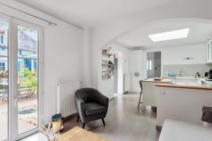 a white kitchen with a chair and a kitchen counter at Maison des Illustres - Welkeys in La Rochelle