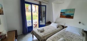 a bedroom with two beds and a door to a patio at Irini Studios in Georgioupolis